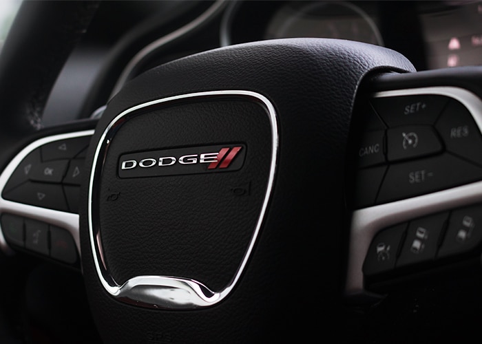 A close-up view of a Dodge steering wheel, showing its design and buttons