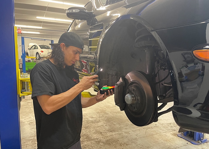 A technician conducting a thorough vehicle inspection, examining various components and systems