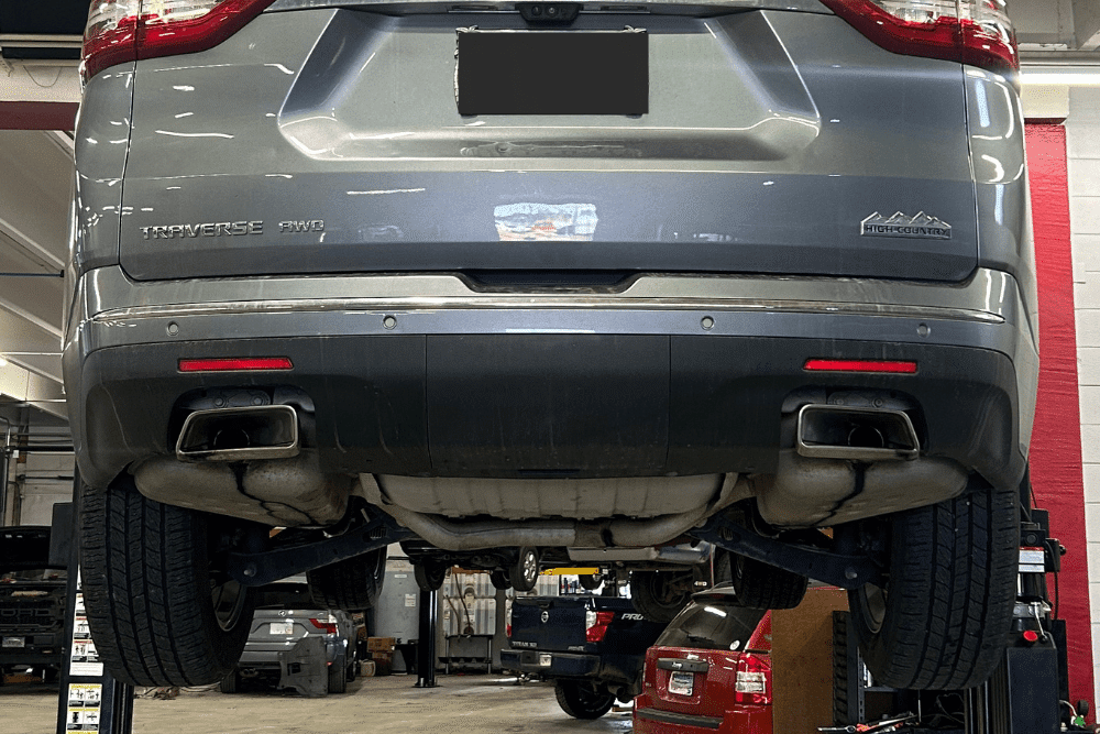 Emissions and exhaust repair in Northglenn, CO by Accurate Automotive. Image of an SUV lifted on a shop hoist, showcasing undercarriage access for safety-focused emissions and exhaust checks.